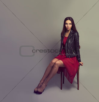 Brunette Woman in Red Dress Sitting on a Chair