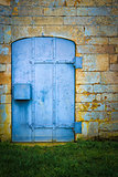 Old blue metal door set in stone