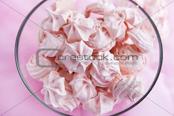 Pink meringues in a glass bowl 