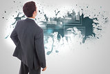 Composite image of businessman standing with hand on hip