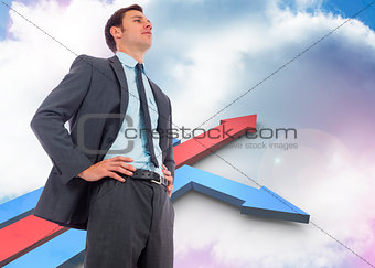 Composite image of stern businessman with hands on hips