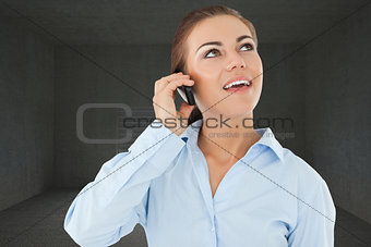 Composite image of smiling businesswoman looking upwards while on her phone