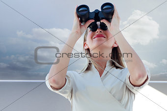 Composite image of businesswoman looking through binoculars