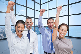 Composite image of cheerful work team posing with hands up