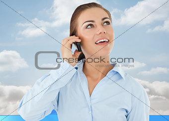 Composite image of smiling businesswoman looking upwards while on her phone