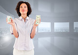 Composite image of serious businesswoman holding dollars and looking upwards