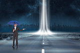 Composite image of peaceful businessman holding blue umbrella