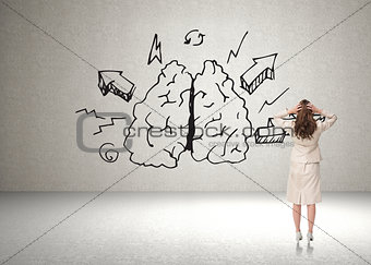 Composite image of businesswoman with hands on head standing back to camera