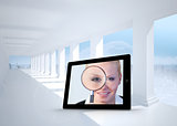 Composite image of businesswoman holding magnfying glass on tablet screen