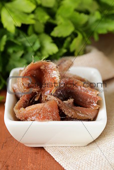 Canned marinated anchovies fillets in a white bowl