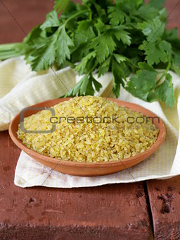 bulgur in a ceramic bowl on wooden table