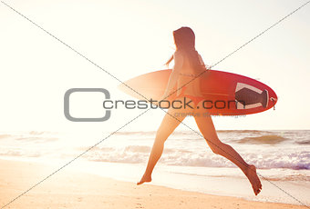 Hot surfer girl at sunset