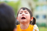 little asian girl crying and look at  her parents