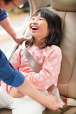 father take care daughter to fasten a seat belt