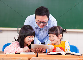 Teacher teaching  children with digital tablet or ipad
