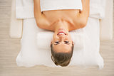 Portrait of happy young woman laying on massage table