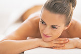 Happy young woman laying on massage table