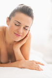 Happy young woman relaxing on massage table