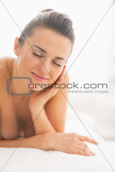 Happy young woman relaxing on massage table