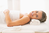 Smiling young woman laying on massage table