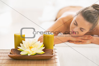 Closeup on spa young woman laying on massage table in background