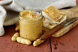 homemade peanut butter with whole nuts on a wooden table