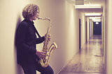 Man playing the saxophone in a hallway