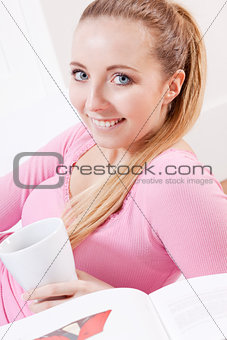 smiling young blond woman drinking coffee
