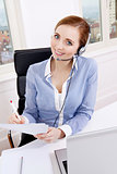 smiling young female call center agent with headset