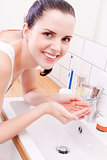 woman washing her face in bathroom