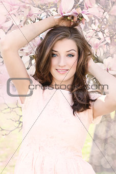 beautiful smiling woman and pink magnolia