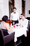 waiter serve fresh espresso for happy couple 