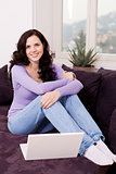 smiling woman on couch with notebook