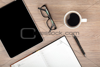 Tablet, notepad, glasses and coffee cup