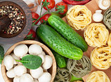 Fresh ingredients for cooking: pasta, tomato, cucumber, mushroom
