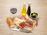 Red wine with cheese, olives, tomatoes, prosciutto, bread and sp