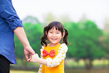 cute girl hold father hand in the park
