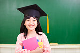 smiling girl wear a graduation hat and holding books