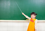  little girl using a baton to point on a blackboard