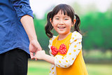 pretty girl hold father hand in the park