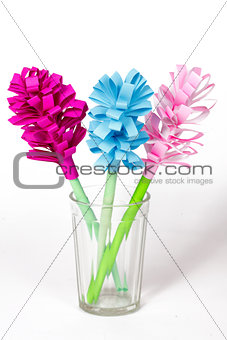Bouquet of colored paper flowers in the faceted glass