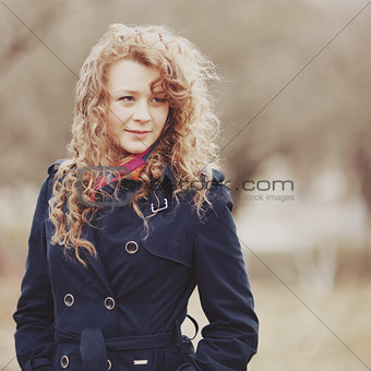 Curly hair spring girl in coat.