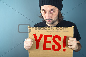 Man holding cardboard paper with word Yes