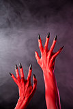Red devil hands with black nails, real body-art 