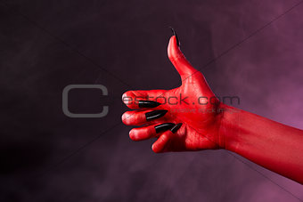 Red devil hand showing thumbs up 