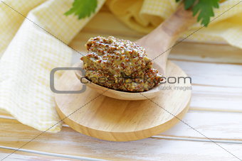 Traditional dijon mustard in a wooden spoon