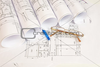 Construction drawings, glasses and pen