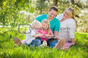 Young Family Enjoys Reading a Book in the Park
