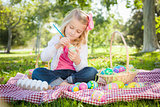 Cute Young Girl Coloring Her Easter Eggs with Paint Brush