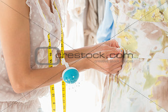 Mid section of a fashion designer working on dress